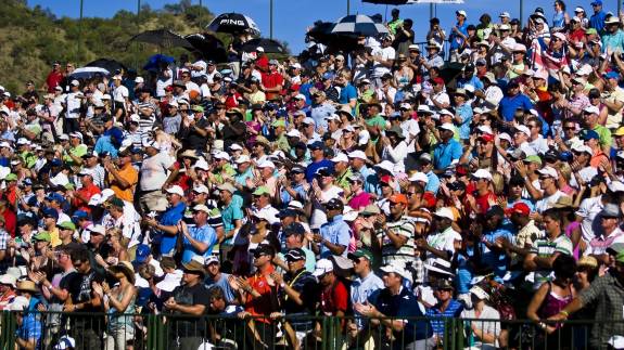 A crowd gather in a grandstand to watch golf