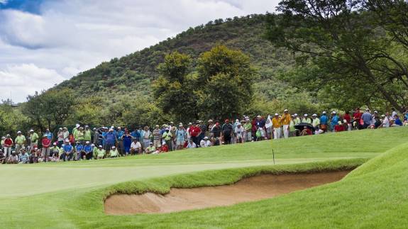 A crowd gathered around a golf green