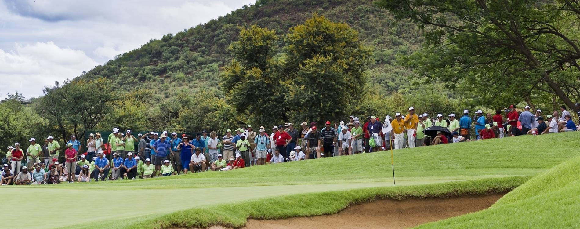 A crowd gathered around a golf green