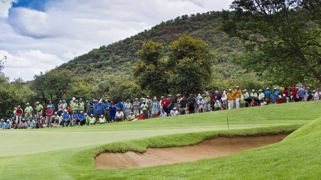 A crowd gathered around a golf green