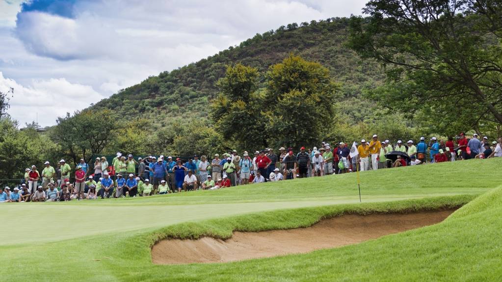 A crowd gathered around a golf green