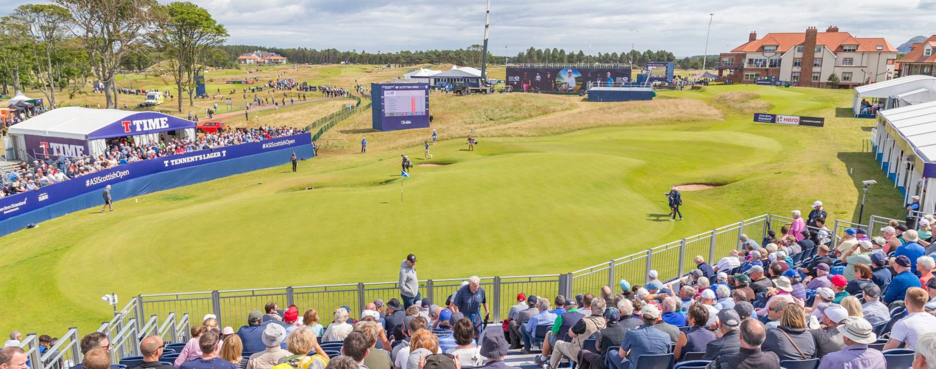 A crowd watches the Scottish Open from a grandstand