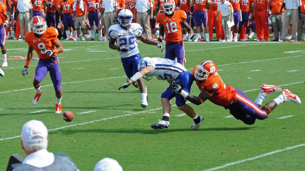 A defensive player sacks a quarterback, resulting in a fumble