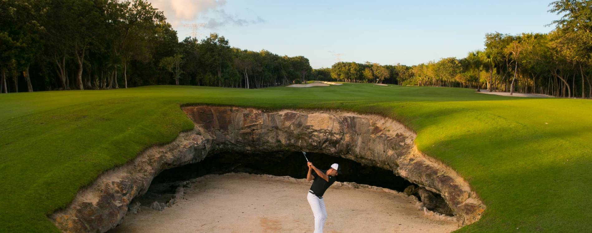 A golfer takes a swing at El Cameleon Golf Club Mayakoba