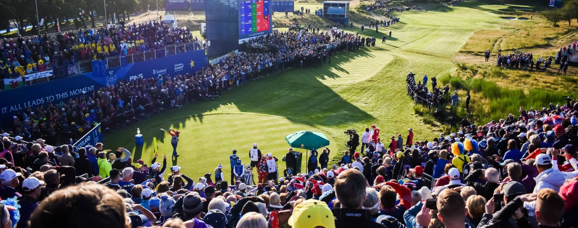 A player tees off in front of an enormous crowd at the Solheim Cup