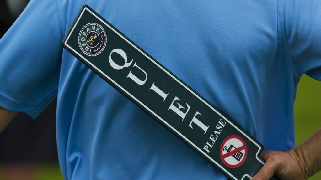 A steward holds a quiet sign