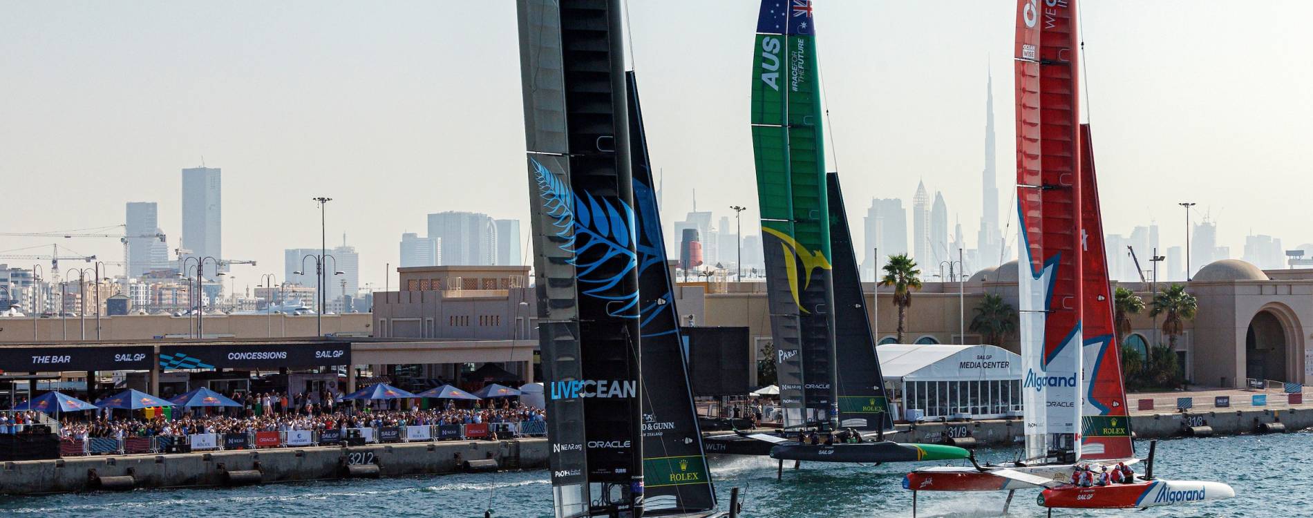 Boats pass the Race Stadium at the Dubai Sail Grand Prix