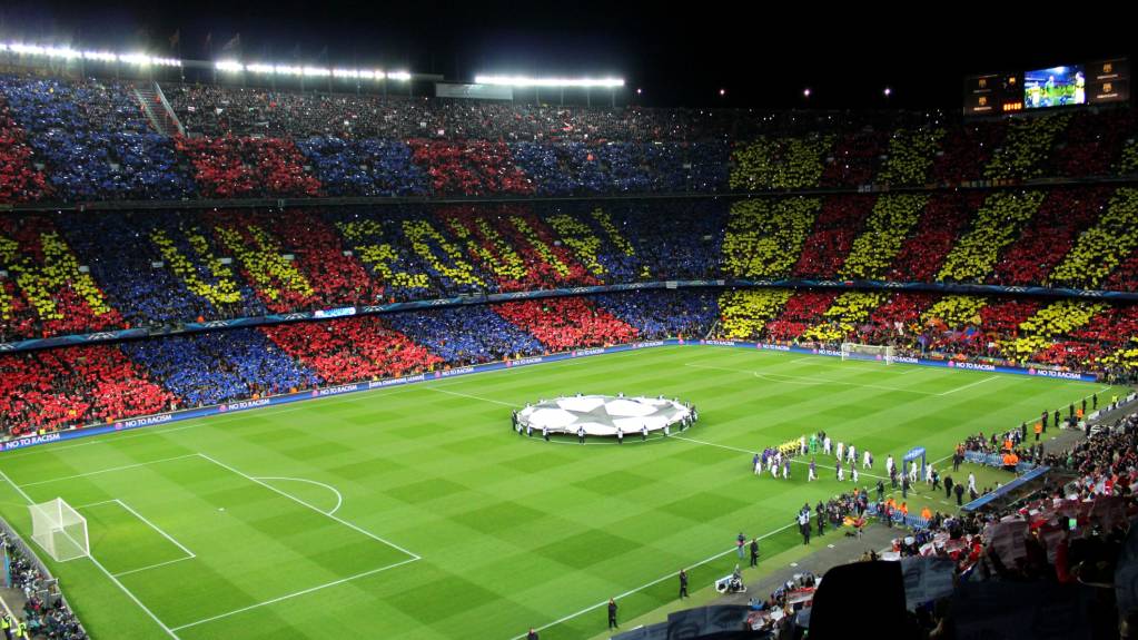 Fans at the Camp Nou watch as Barcelona and AC Milan line up in the Champions League