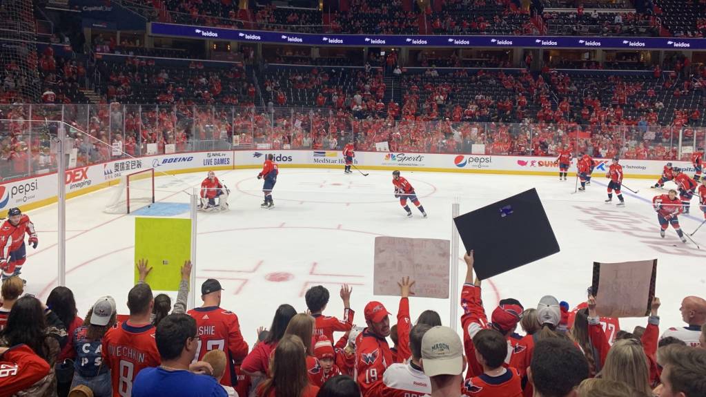 Fans hold up signs at an NHL game