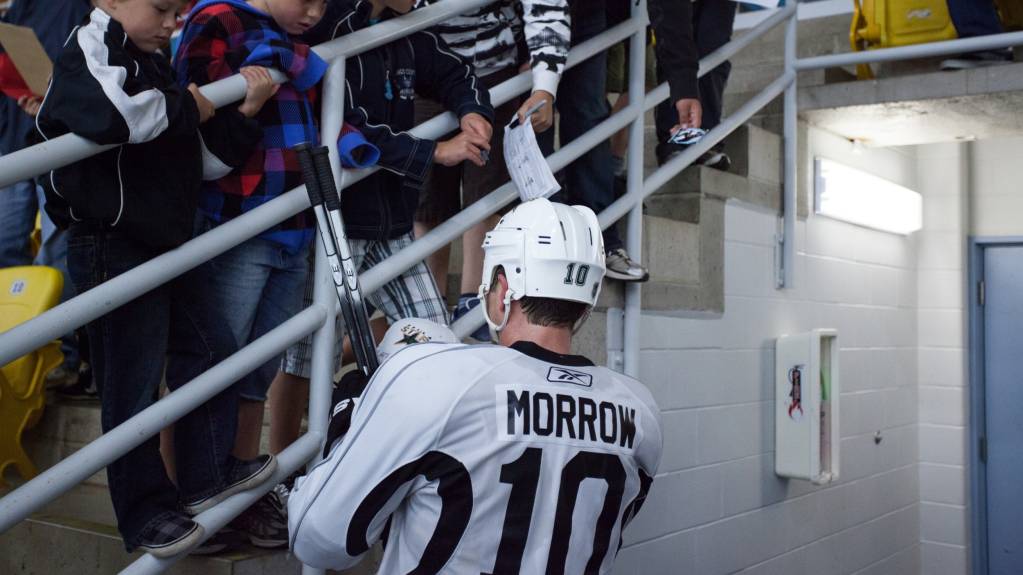Hockey player signs autographs for fans