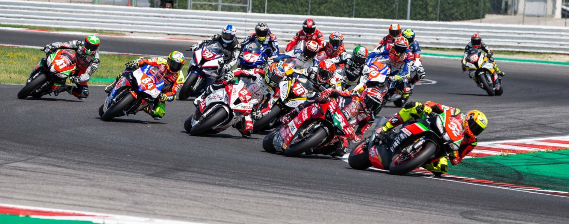 Riders cluster round a corner at the Misano World Circuit