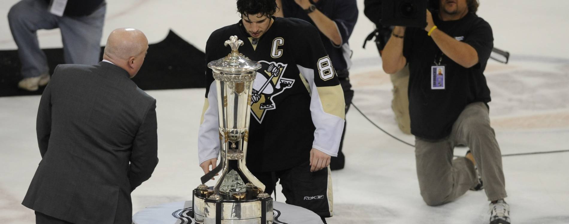Sidney Crosby stands beside the Prince of Wales Trophy